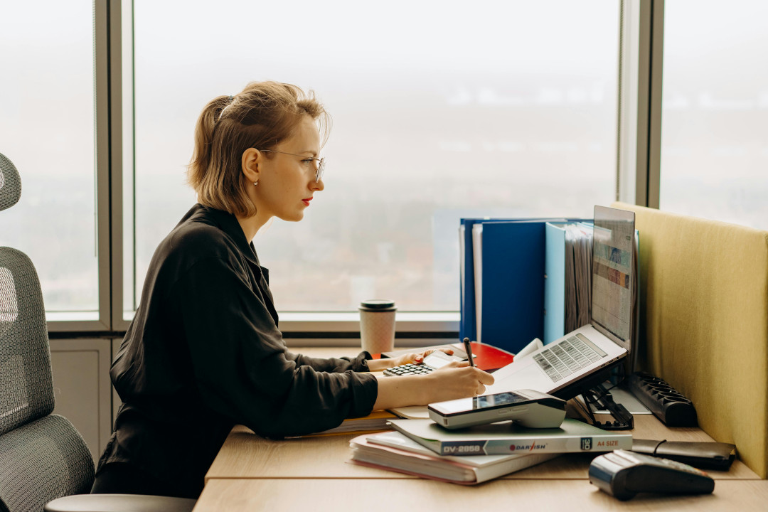 Photo of a young woman in an office working at a computer