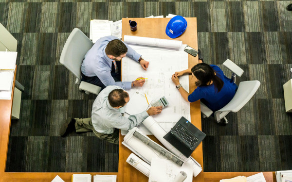 Construction industry staff reviewing financial and project documents at a building site